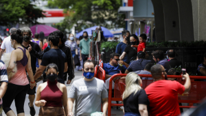 pessoas caminhando na rua de máscara