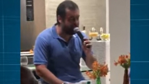 Homem de camisa azul falando em microfone