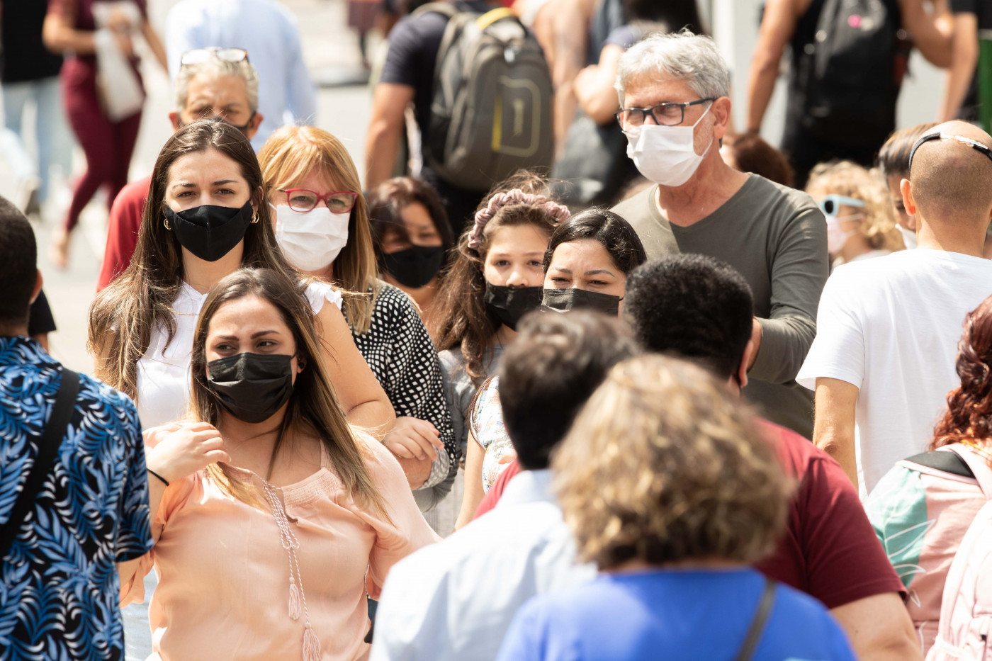 pessoas na rua usando máscara