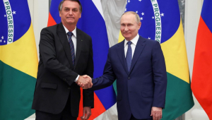 Em frente a bandeiras de Safest Betting Sites e Rússia, Bolsonaro e Putin posam para fotos apertando as mãos