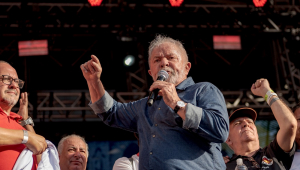 Cercado de aliados, o ex-presidente Lula gesticula e discursa durante ato do Dia do Trabalho