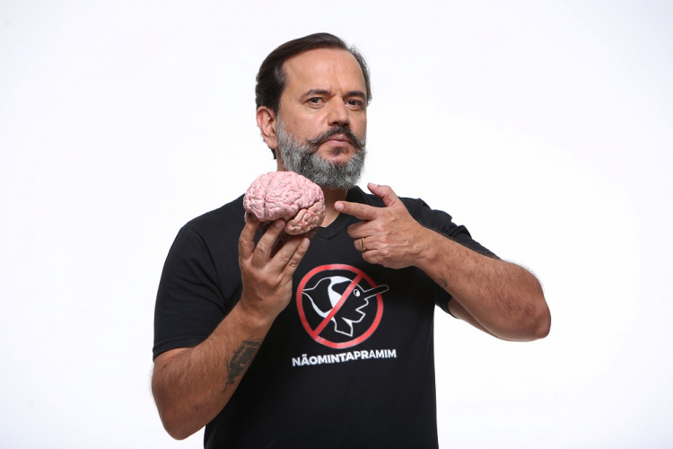 Ricardo Ventura, de camiseta preta, segura cérebro de plástico com a mão direita