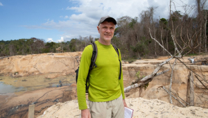 Dom Phillips: homem branco de meia idade com caderno na mão na Amazônia
