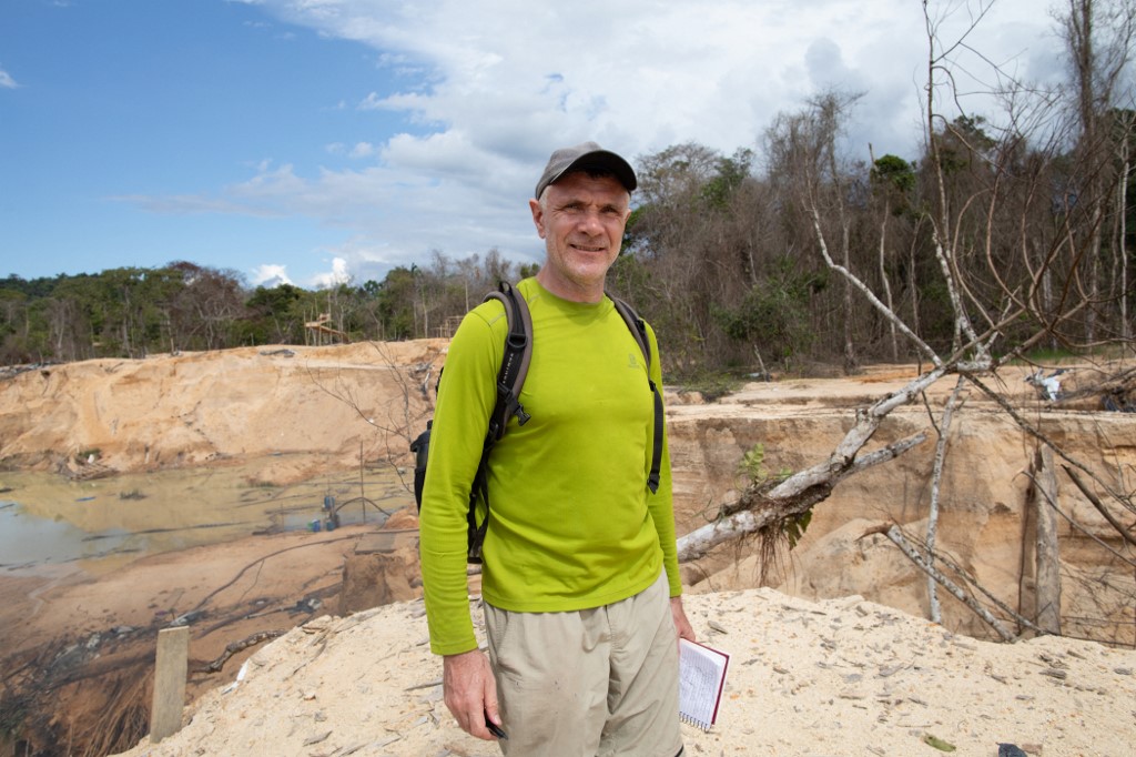 Dom Phillips: homem branco de meia idade com caderno na mão na Amazônia