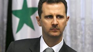 O presidente da Síria, Bashar al-Assad, posa para foto em frente à bandeira nacional