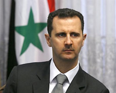 O presidente da Síria, Bashar al-Assad, posa para foto em frente à bandeira nacional
