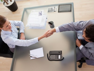 pessoas se dando a mão em uma entrevista de emprego