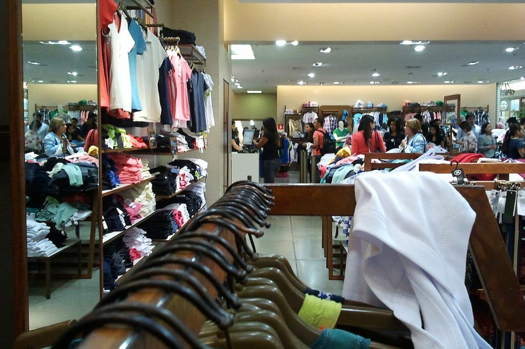 Interior de loja de roupas com diversos consumidores