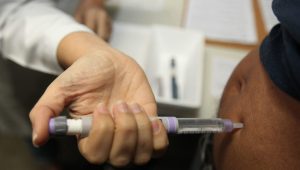 Imagem de uma enfermeira aplicando insulina em uma mulher