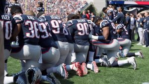 Jogadores do New England Patriots ajoelhados durante a execução do hino nacional