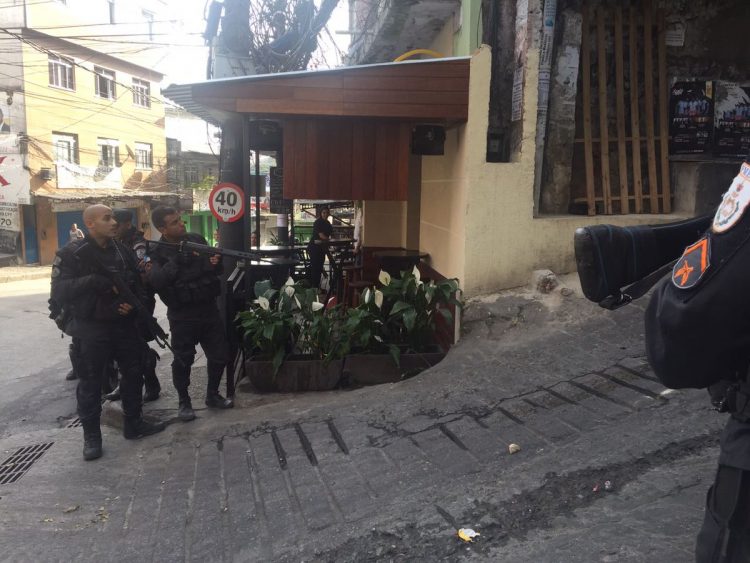 Policiais armados analisam local em ação na favela da Rocinha, no Rio de Janeiro
