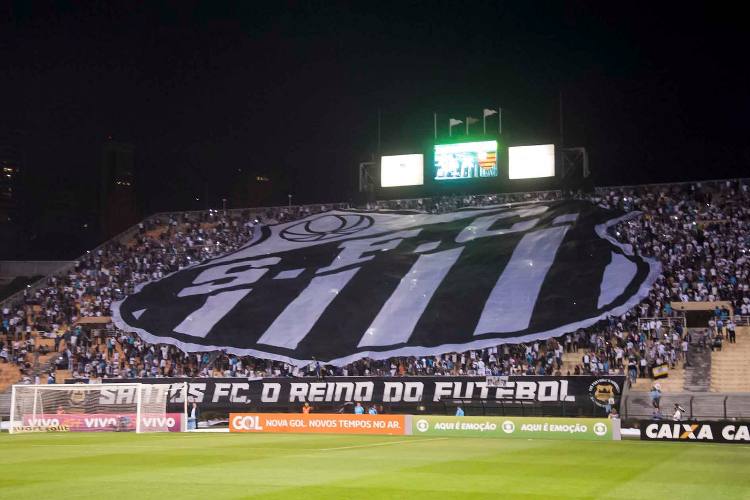 Bandeirão com o escudo do Santos estendido sobre os torcedores no Tobogã do Pacaembu