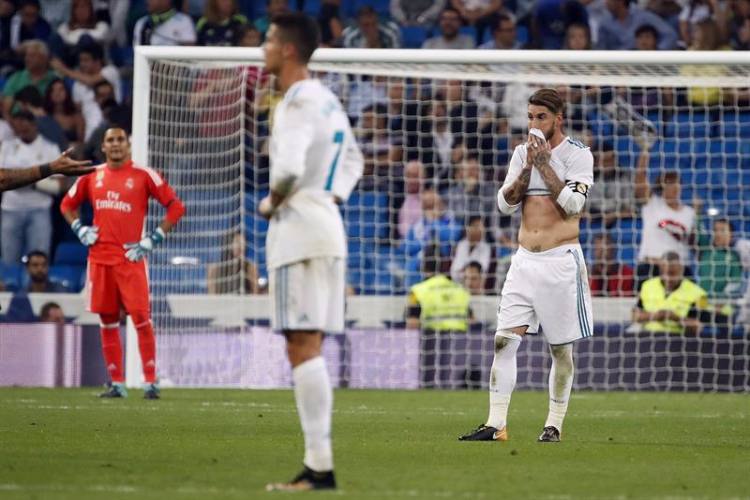 Sergio Ramos, com a camisa levada a boca, e Cristiano Ronaldo, com as mãos na cintura, lamentam derrota do Real Madrid no gramado