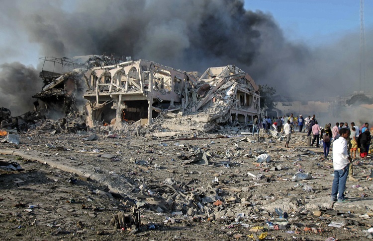 Moradores em frente ao Safari Hotel, em Mogadíscio, capital da Somália, após explosão de caminhão-bomba