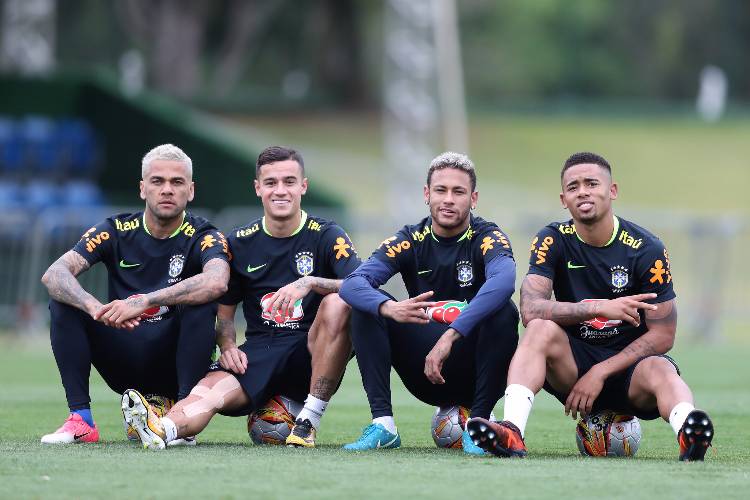 Daniel Alves, Philippe Coutinho, Neymar e Gabriel Jesus sentados em cima de bolas de futebol
