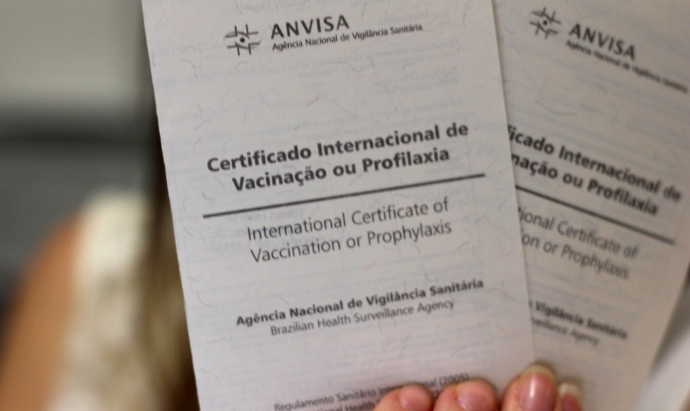 Pessoa segurando o Certificado Internacional de Vacinação
