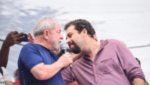 Guilherme Boulos fala ao pé do ouvido de Lula em palanque
