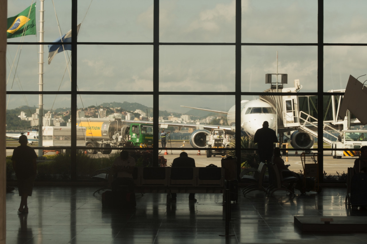 Passageiros aguardam no Aeroporto Santos Dumont nesta sexta (25) enquanto aviões recebem combustíveis