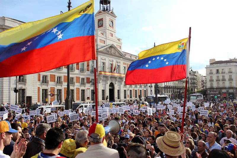Pessoas agitando bandeiras da Venezuela durante um protesto