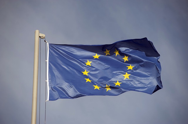 Bandeira da União Europeia em um lastro. Ao fundo, céu nublado