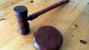 martelo marrom jurídico apoiado em cima de uma mesa