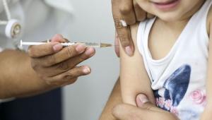Enfermeira aplicando vacina em uma criança