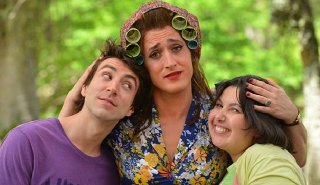 Três pessoas, no meio o ator Paulo Gustavo, caracterizado com roupas ditas femininas durante cena do filme 'Minha Mãe é uma Peça'. Abraçado no ator e na atriz que fazem seus filhos.