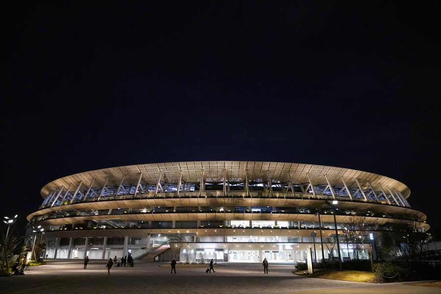 Foto de um dos estádios de Tóquio. É oval, bastante espelhado e com cor meio marrom