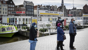 Pessoas usando máscara andam por Amsterdã, capital e maior cidade da Holanda