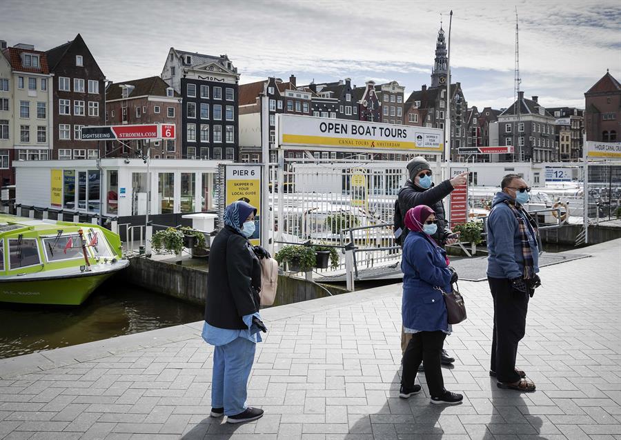 Pessoas usando máscara andam por Amsterdã, capital e maior cidade da Holanda