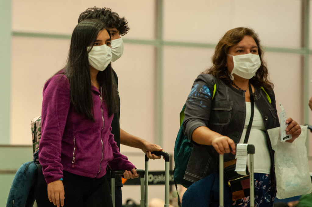 Pessoas usam máscara de proteção durante viagem