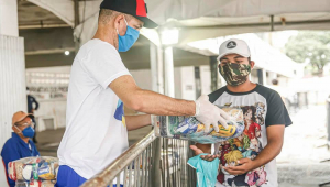 pessoa distribuindo uma cesta básica