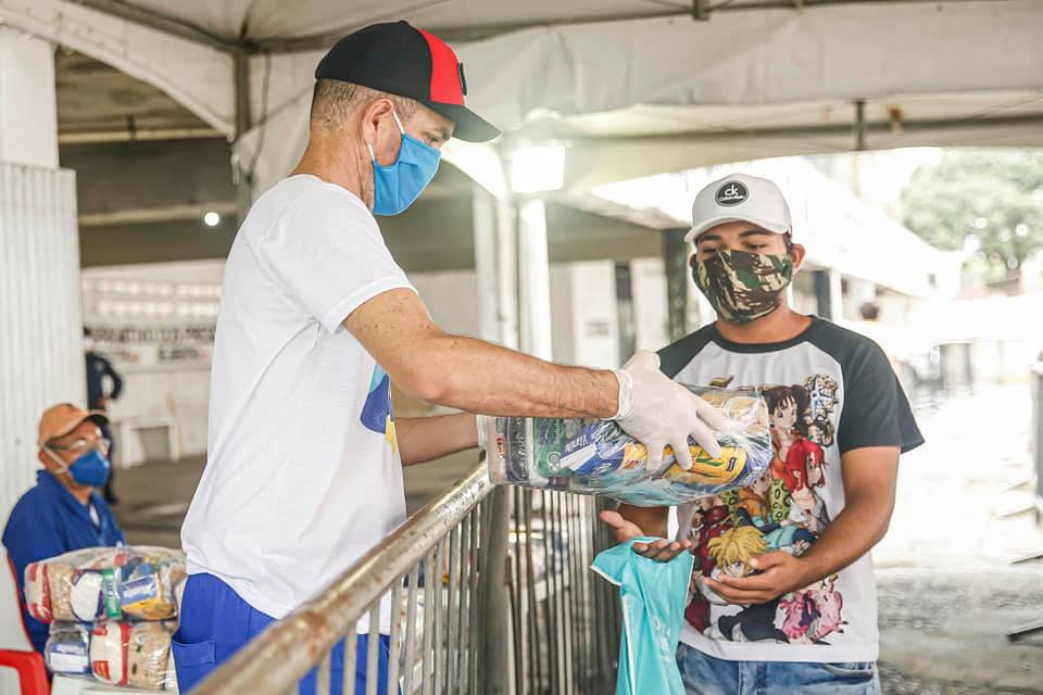 pessoa distribuindo uma cesta básica