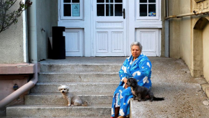 Idosa sentada na porte de casa com um cachorro