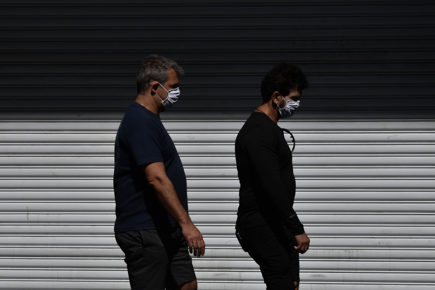 Pessoas caminham de máscara pelas ruas de São Paulo