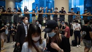 Pessoas asiáticas usando máscaras e caminhando dentro de um espaço