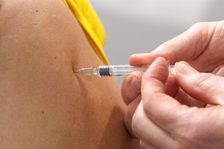 Profissional da saúde aplica vacina no braço de um paciente