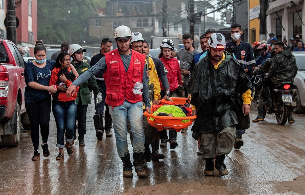 Uma pessoa é transportada em maca por serviços de emergência do local de um deslizamento de terra causado por fortes inundações em Petrópolis