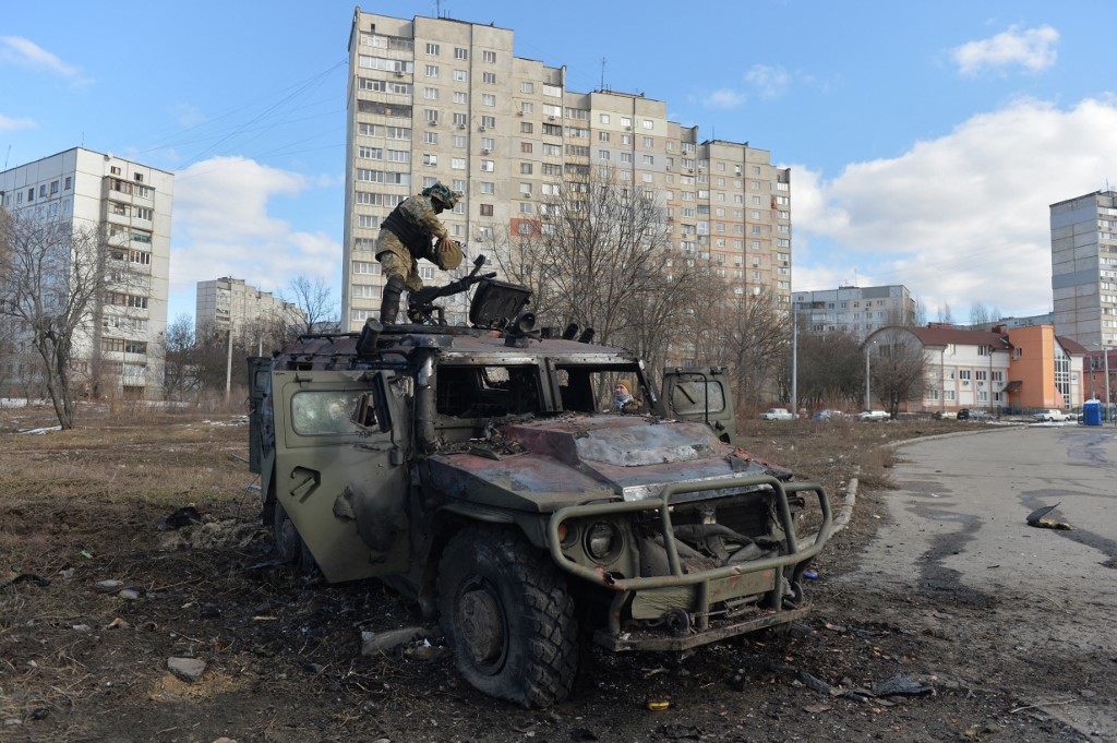 caça ucraniano da Defesa Territorial examina um veículo de infantaria russo destruído