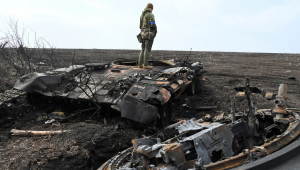 Soldado ucraniano sobre os destroços de um tanque russo queimado fora da vila de Mala Rogan, a leste de Kharkiv