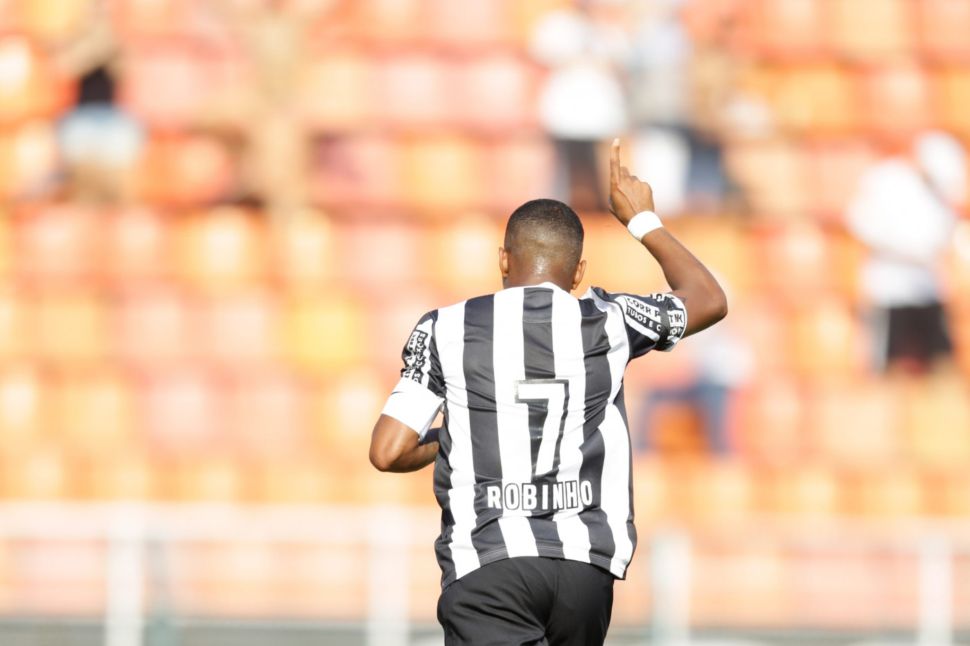 Robinho de costas em jogo do Santos, usando uniforme listrado do clube