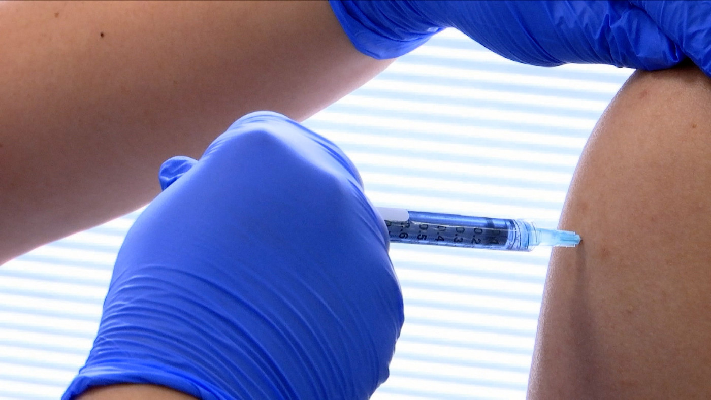 pessoa aplicando vacina no braço de outra