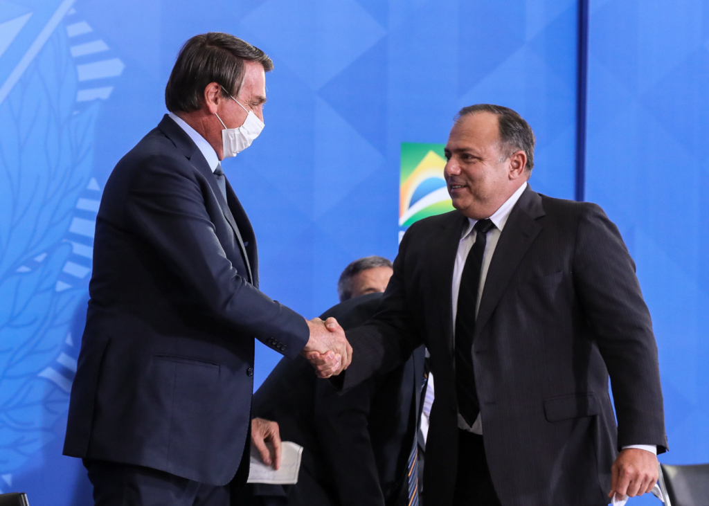 O presidente Jair Bolsonaro segura a mão do ex-ministro Eduardo Pazuello