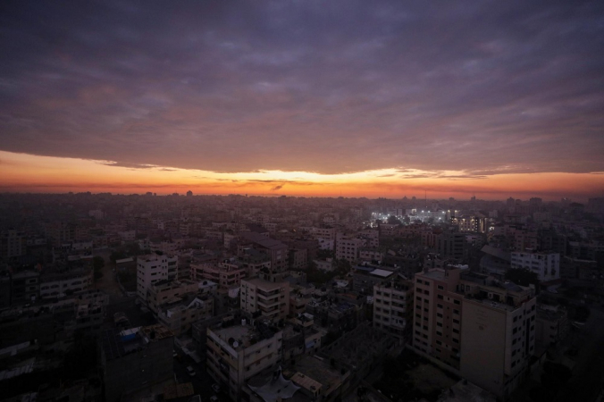 Al Shifa hospital is lit up during sunrise in Gaza City