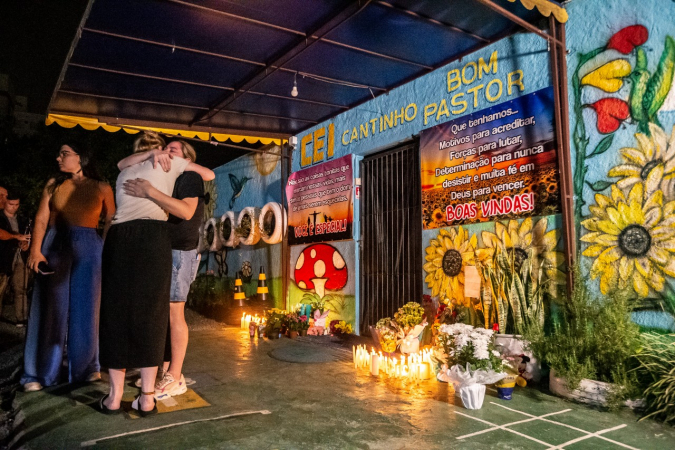 Mulheres se abraçam durante vigília realizada na noite desta quarta-feira, 5, na frente da creche Cantinho Bom Pastor, em Blumenau (SC)