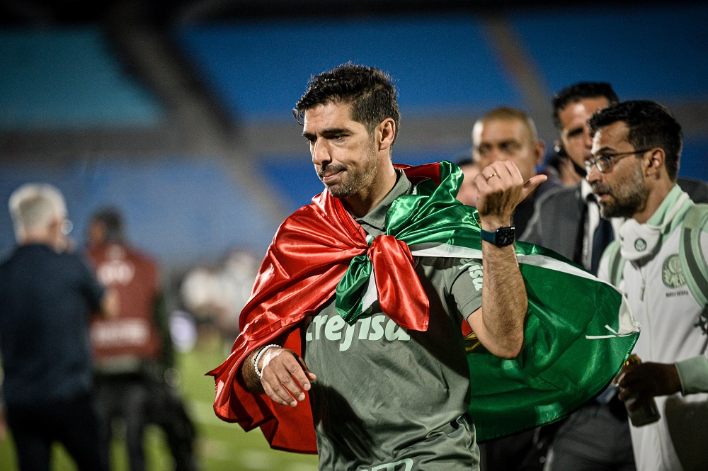 Com uma bandeira do Palmeiras amarrada no pescoço, Abel Ferreira celebra título da Libertadores em campo