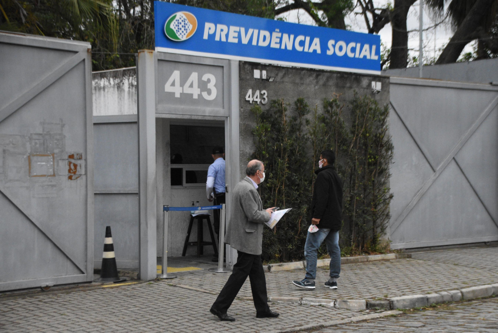 Pessoas em frente a uma agência da Previdência Social