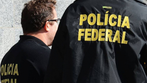 Dois homens de costas com coletes da Polícia Federal