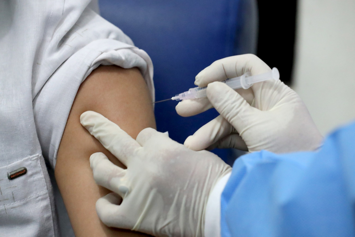 Profissional da saúde aplica vacina em paciente