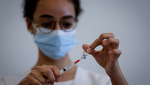 pessoa colocando líquido em seringa de vacina
